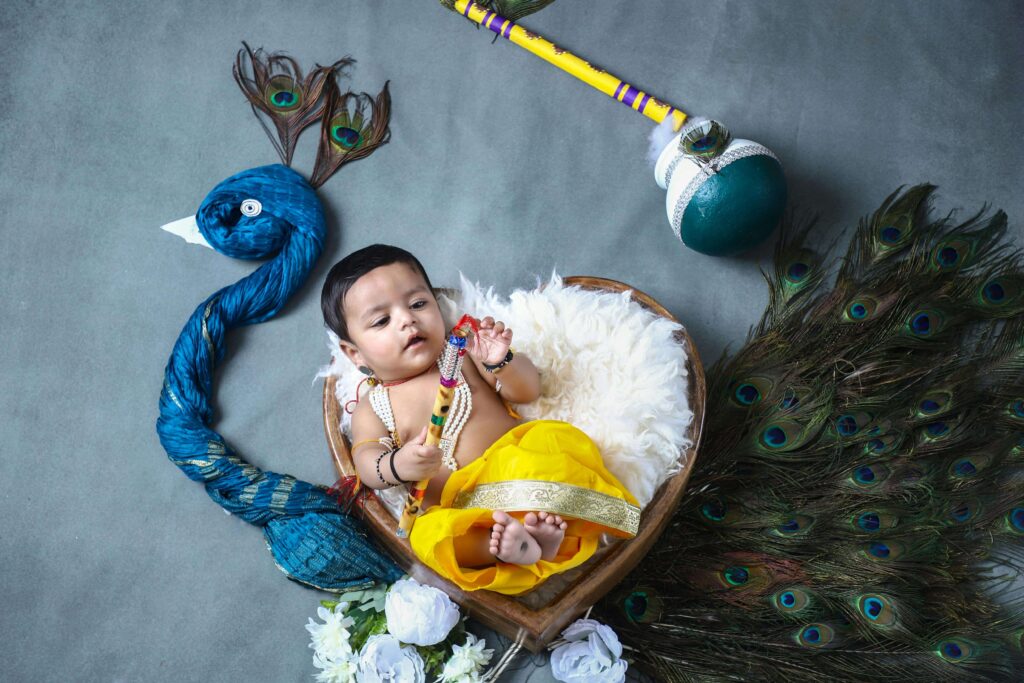 A baby boy lies in a heart-shaped bed above the image of a peacock.